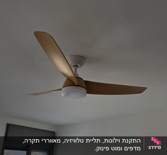 מאוורר תקרה מותקן בחדר עם חלון גדול